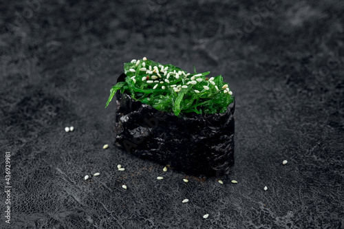 Sushi with seaweed and sesame seeds on a stone background. Japanese dish chuka sushi, close up photo