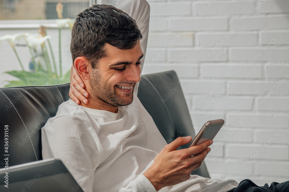 young man with mobile phone at home sitting on the sofa young man with mobile phone at home sitting on the sofa