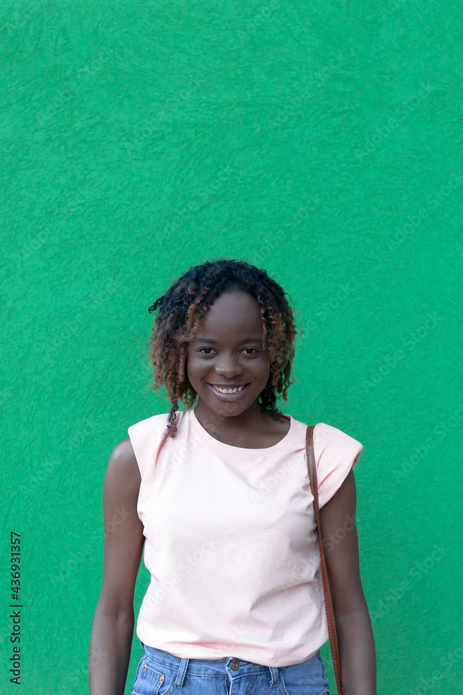 Young beautiful happy African American woman on a green background. Human emotions Young beautiful happy African American woman on a green background. Human emotions