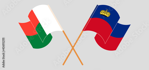 Crossed and waving flags of Madagascar and Liechtenstein