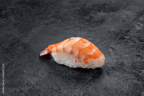 One nigiri sushi with prawn on a stone dark background. Japanese dish sushi ebi photo