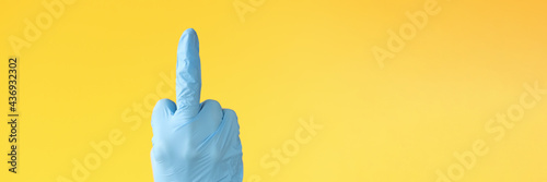 Billede på lærred Hand in rubber glove showing middle finger closeup