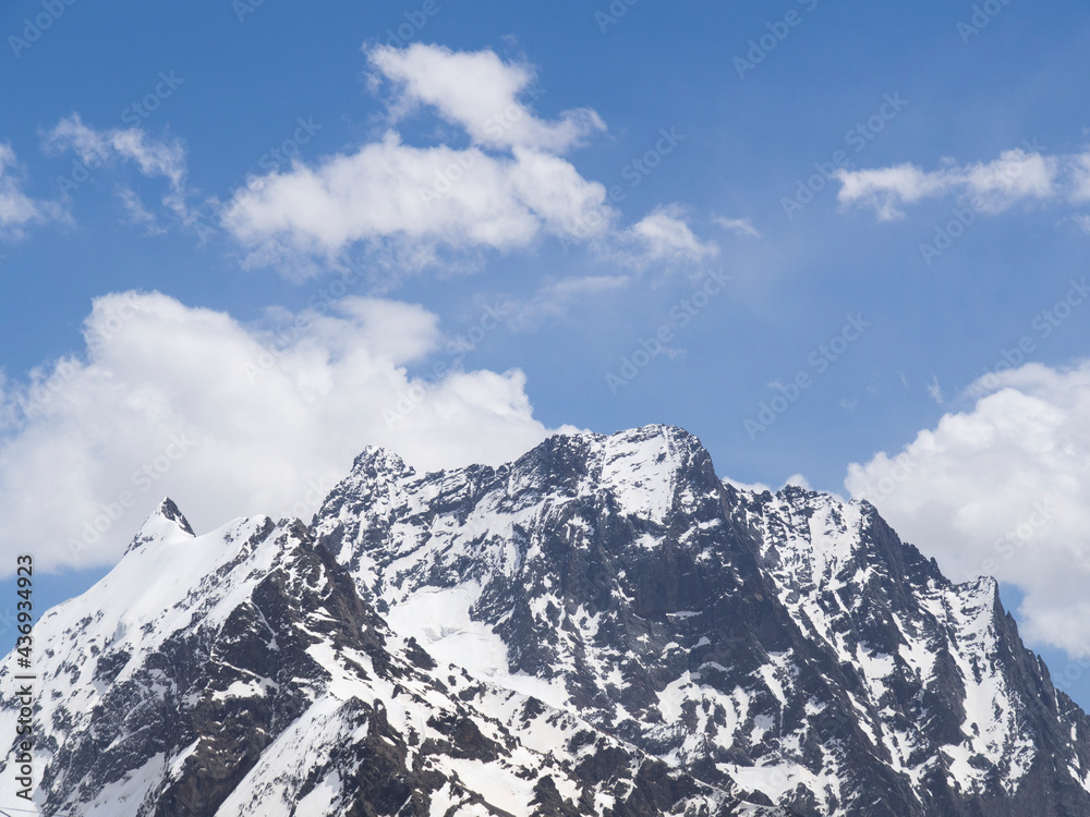 A landscape with a view of a mountain snow-covered peak. Travel, tourism to the Caucasus Mountains, Dombay. The concept of wildlife without a trace of humans.
