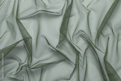 wrinkled, compressed fabric mesh tulle green on white isolated background close-up. background for your design