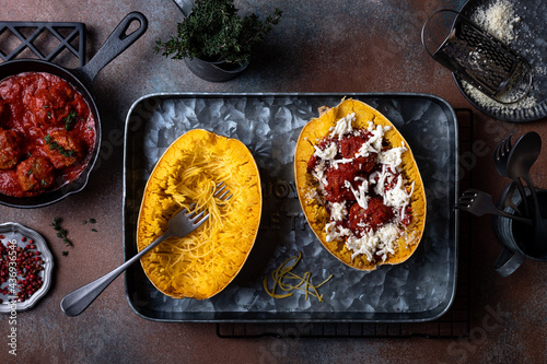 Cooking stuffed Spaghetti squash with meatballs in tomato sauce photo