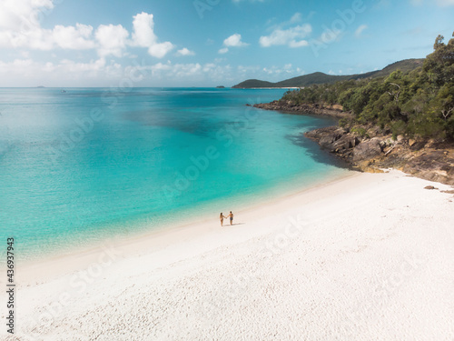 Aerial view of a couple walking and holding hands on South Whitehaven beach, Queensland, Australia.