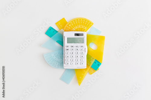 School rulers and calculator on grey background. Top view with copy space. Flat lay. Back to school concept.