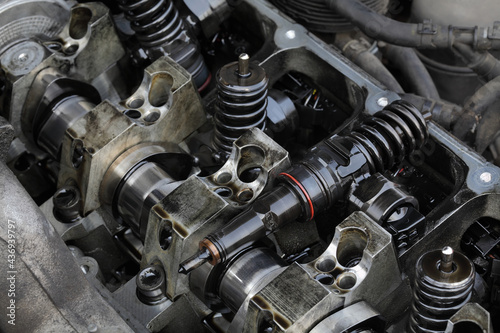 Detail of modern diesel engine repair, closeup of injectors in cylinder head with camshaft photo