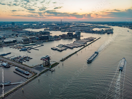 Aerial view of city harbour with boats docked at sunset along Buiten IJ canal in Amsterdam, North Holland, Netherlands. photo