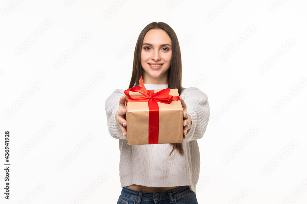 Happy young woman holding gift box over gray background Happy young woman holding gift box over gray background