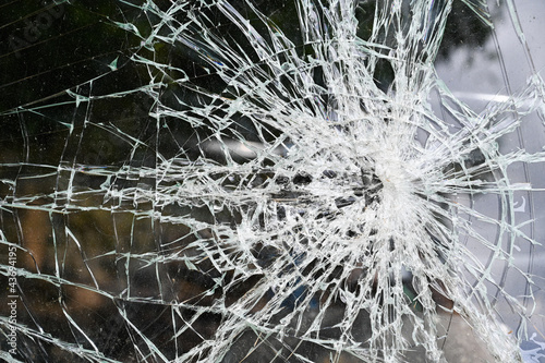 Broken car windshield with cracks. Smashed glass on a black background, close up. Cracked glass in accident. 