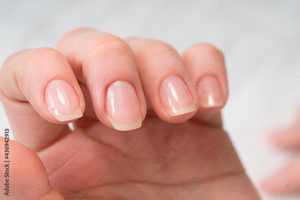 Woman in a nail salon receiving a manicure by a beautician with nail file. Beauty and hand care close-up. Woman in a nail salon receiving a manicure by a beautician with nail file. Beauty and hand care close-up.