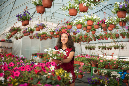 Female gardener holding plant and smiling