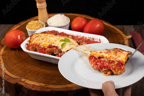 Tasty Steak Parmegiana or Parmegian Filet, made with breaded steak, tomato sauce, cheese au gratin. Accompanied by white rice and potato straw. Being served on the white plate, highlight the cheese photo