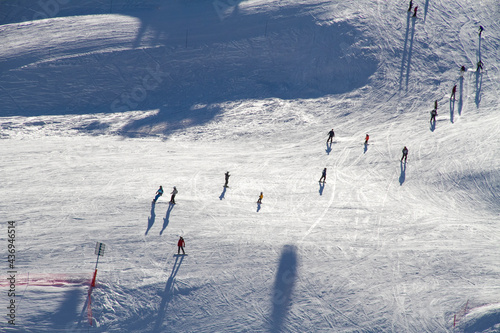 Skiers and snowboarders going downhill on a snowy mountain 