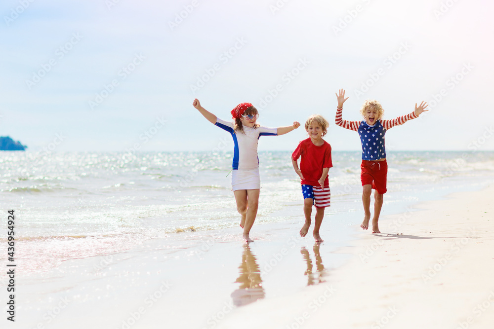 Kids with American flag on beach. 4th of July.