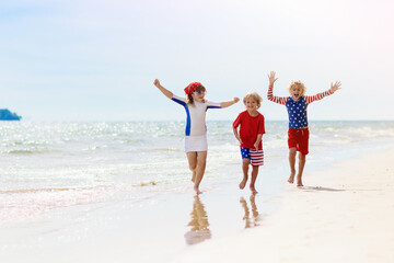 Kids with American flag on beach. 4th of July.