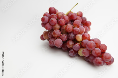 Fresh and ripe red grapes isolated in white background. Bunch of raw and juicy grapevines