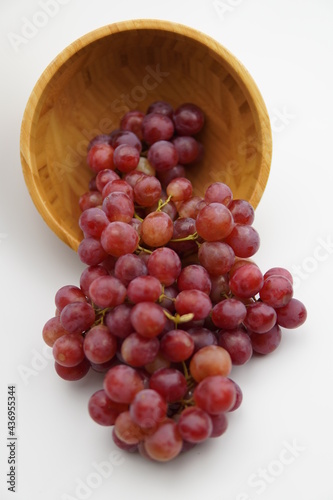 Wallpaper Mural Fresh and ripe red grapes in a wooden bowl, isolated in white background. Bunch of raw and juicy grapevines Torontodigital.ca