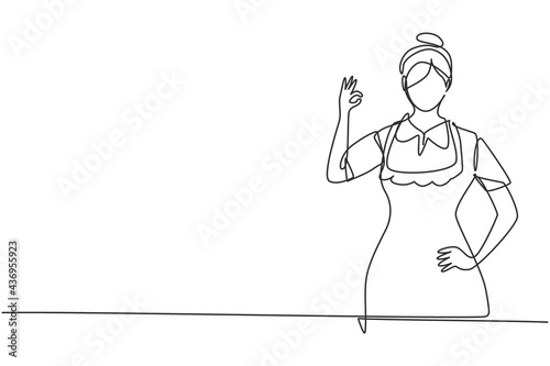 Single continuous line drawing maid in hotel with gesture okay and in neat uniform. Tidying up messy bed in hotel room. Professional person. Dynamic one line draw graphic design vector illustration