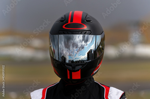 A  Racer's visor reflects a cloudy sky after a light rain between races photo