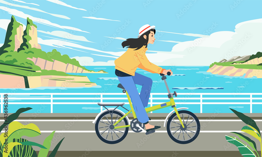 Fototapeta premium a woman rides a bicycle along a seaside road with beautiful sea landscape behind her