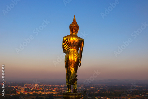 Back view of golden buddha with sunset in evening