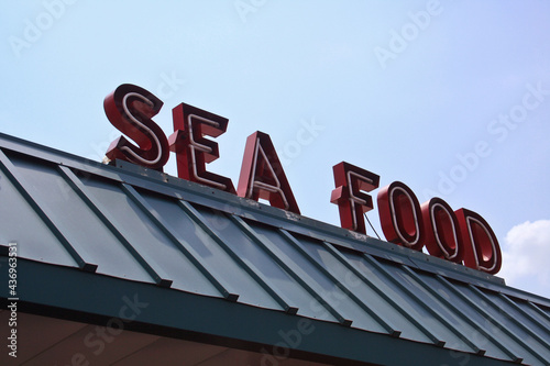 Restaurant Sign Outdoors On Building Roof With Blue Sky © LMPark Photos