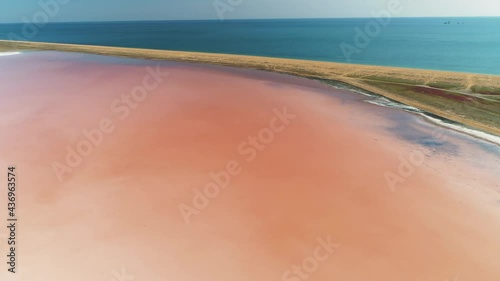 Flight forward beautiful Crimea Koyashskoe pink salt lake coastline black sea strip of land contrast.  Kerch Peninsula Russia travel landmark. Algae blooming. National park reserve. Summer. Horizon photo