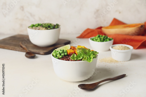 Bowls with tasty quinoa salad on light background