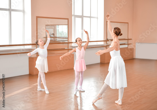 Little ballerinas training with coach in dance studio