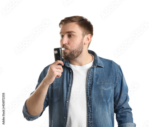 Fotografie Man blowing into breathalyzer on white background