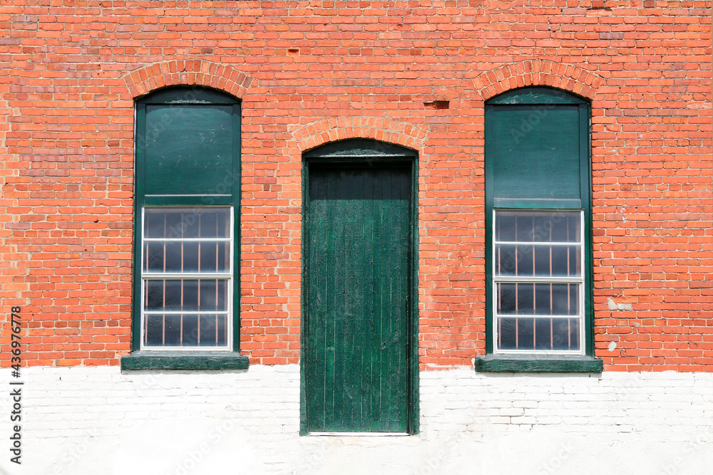 old town village red brick and white painted abandoned factory warehouse store door and windows trimmed in green old town village red brick and white painted abandoned factory warehouse store door and windows trimmed in green