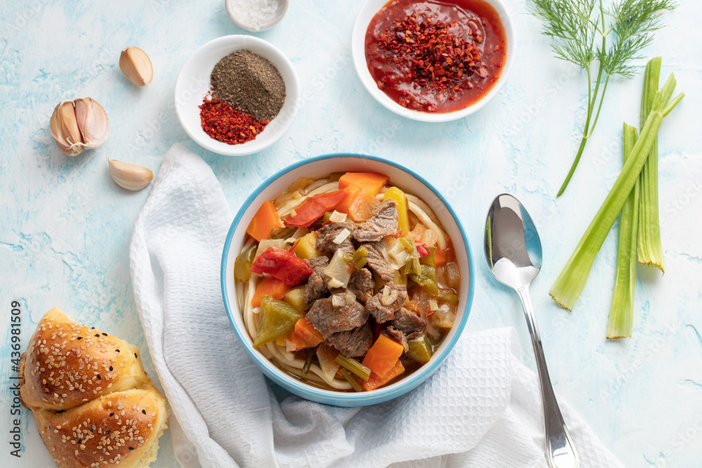 Uzbek food with noodles, vegetables and spices Lagman. Uyghur-style lagman with undercooked vegetables. Uzbek and Central Asia cuisine concept. Flatlay view Uzbek food with noodles, vegetables and spices Lagman. Uyghur-style lagman with undercooked vegetables. Uzbek and Central Asia cuisine concept. Flatlay view