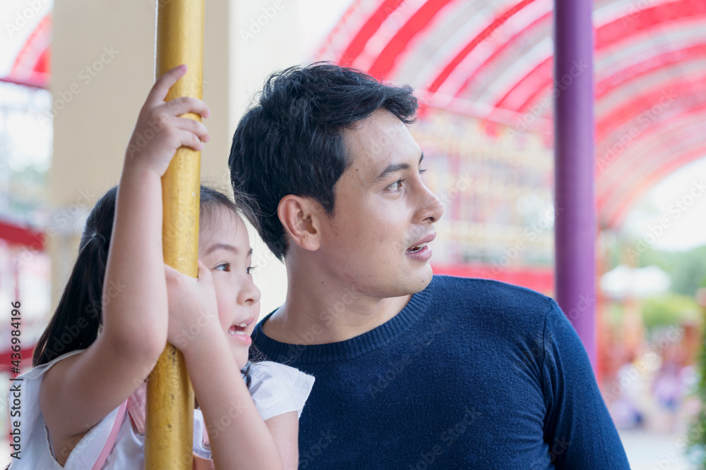 Obraz premium Father and daughter playing rides in the amusement park