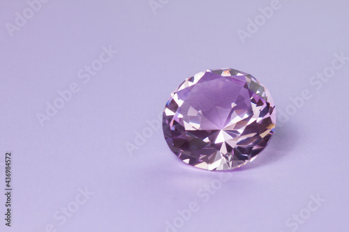 Purple precious gemstone for design gems jewellery. Big diamond crystal on purple background.