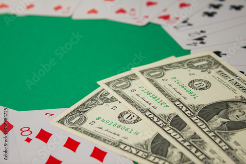 Classic playing cards and dollars on green background with place for text. Gambling and casino concept.