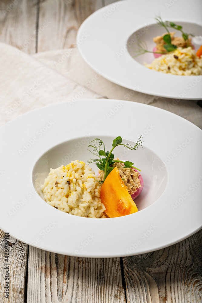 Risotto with seafood. Egg with smoked mackerel pate. Honey orange tomato. Gourmet cuisine. Food photography and styling. Mediterranean Kitchen. Vertical shot. Close-up. Delicious and healthy eating