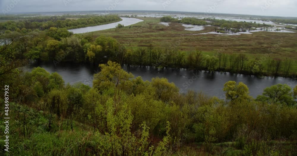 Beautiful view to the landscape with a meander river in a rainy cloudy day. Top view from hill to the green summer landscape in a rainy day. Panning of the river while flood. Beautiful view to the landscape with a meander river in a rainy cloudy day. Top view from hill to the green summer landscape in a rainy day. Panning of the river while flood.