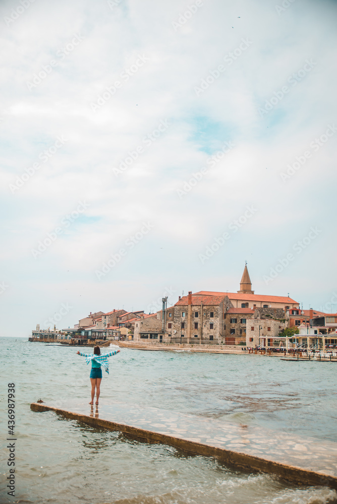 woman walking by umag city quay at stormy weather. copy space