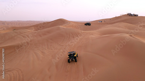 AERIAL. ATV travelling in sand desert.