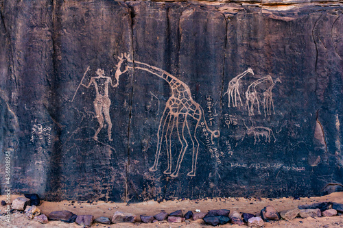 Neolithic rock art. Prehistoric rock engraving  depicting a human and a giraffe. Wilaya Tamanrasset, Hoggar Mountains,Tassili nAjjer National Park, South Algeria, Africa,