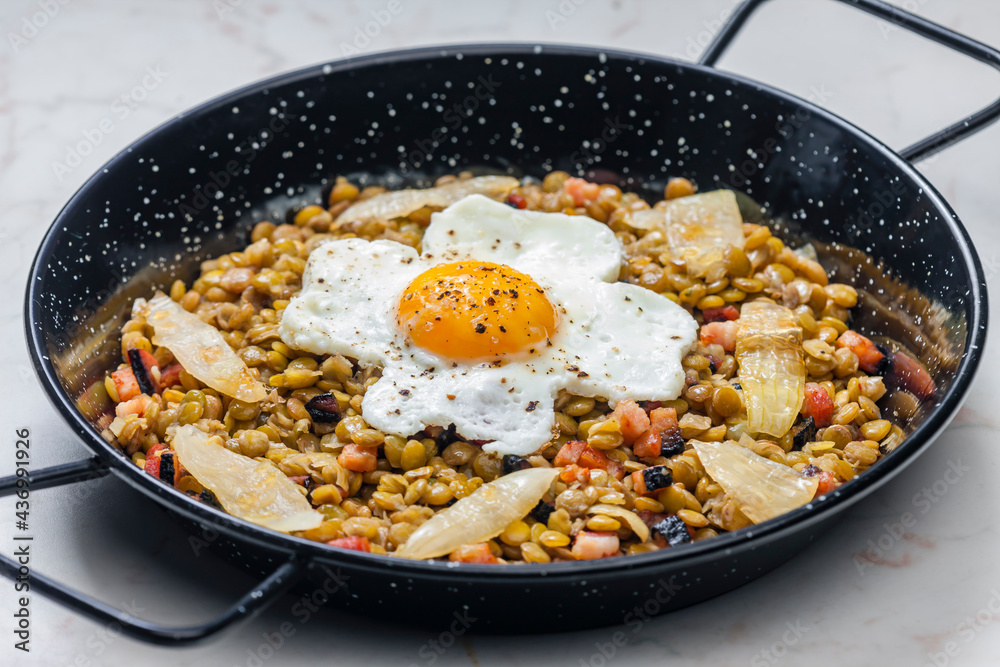 lentils with smoked meat and onion served with fried egg lentils with smoked meat and onion served with fried egg