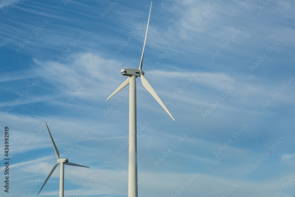 Windmill turbine propeller against blue sky. Natural green energy conservation concept Windmill turbine propeller against blue sky. Natural green energy conservation concept