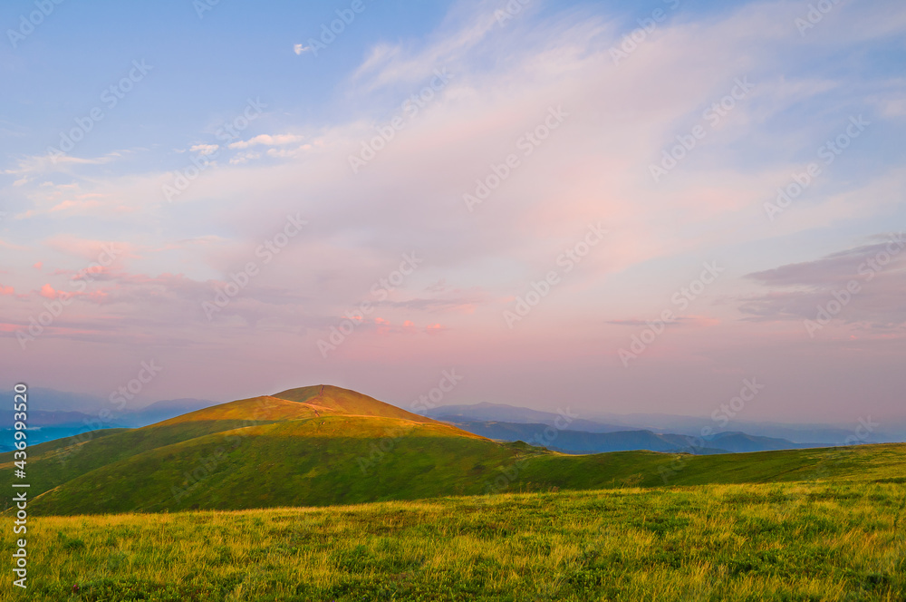 Summer mountain landscape: the mountain top glows with light at sunset. Europe, Ukraine, the Carpathian Mountains, the ridge Borzhava.