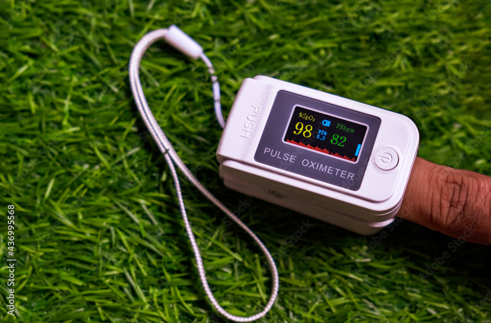 Close up of finger in a pulse oximeter device with oxygen saturation level and pulse rate display Close up of finger in a pulse oximeter device with oxygen saturation level and pulse rate display