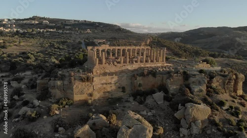 Aerial: Temple of Juno on cliff top in Agrigento Italy in golden light photo