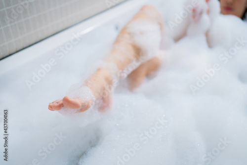 Woman's feet bathe in the bathtub