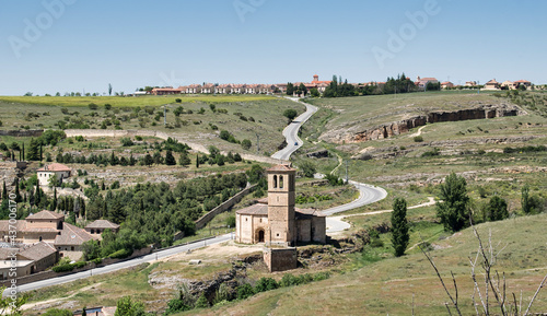 Iglesia románica de la vera cruz y pueblo de Zamarramala en el horizonte, Segovia, España photo