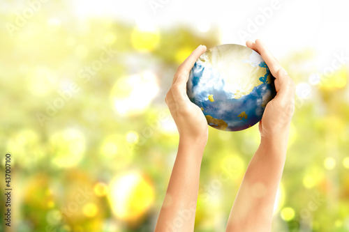 Fototapeta Naklejka Na Ścianę i Meble -  Hand holding the earth with blurred light background